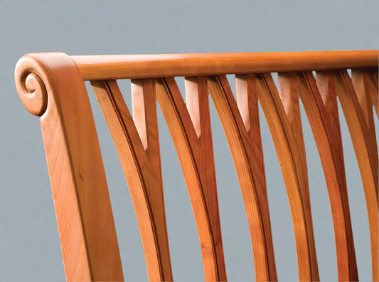 detail of fork-back with bead headboard hand carved curl in cherry on black background